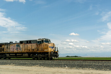Fototapeta na wymiar Freight Train Traveling Across Field