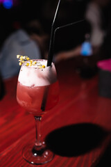Close-up of an alcoholic cocktail decorated with a flower in a nightclub, bar