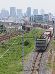 Fototapeta na wymiar 高層ビルを背景にした貨物列車