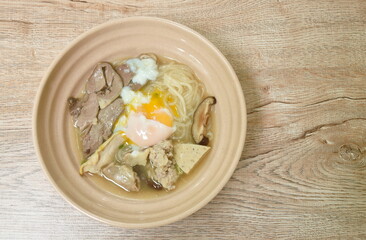 Vietnamese rice noodles or Pho with slice sausage and entrails with chop pork topping soft boiled egg in soup on bowl