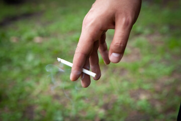 young guy holding a cigarette