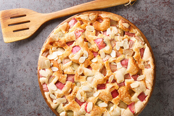 Traditional fresh rhubarb pie with almonds close-up in a dish on the table. horizontal top view from above