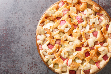 Scandinavian Rhubarb Cake with almond flakes closeup in the plate on the table. Horizontal top view from above