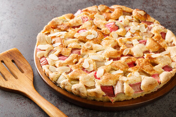 Sweet and sour delicious rhubarb pie with almonds close-up in a dish on the table. horizontal