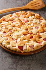 Delicious homemade rhubarb pie with almonds close-up in a dish on the table. vertical