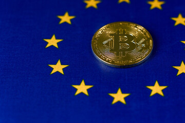 Gold bitcoin coin in the center of the EU flag, close up