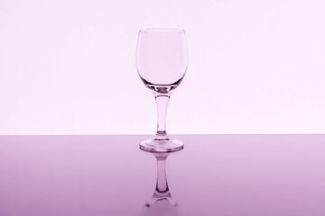 Empty wine glass with reflection on background, toned