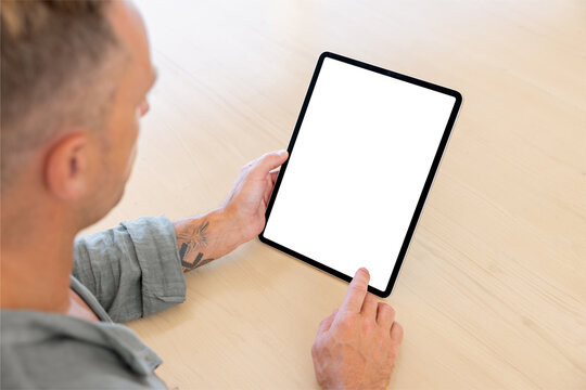 Man Using Tablet Computer, Empty White Screen Mockup, Over The Shoulder View