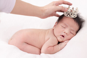 Behind the scenes of the shooting newborn baby. Photographer setting pose of newborn baby carefully.