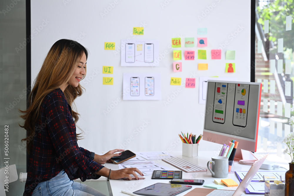 Poster side view of female web application developer working at modern office.