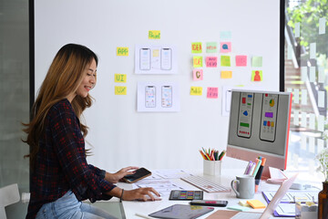 Obraz na płótnie Canvas Side view of female web application developer working at modern office.