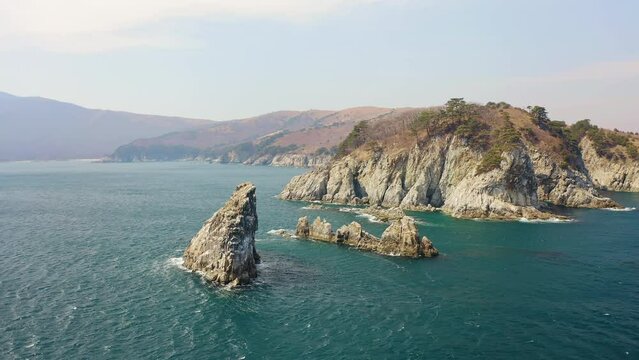 Kekura and rocky Cape Telyakovsky washed by the Sea of Japan on a sunny day. Far Eastern Marine Reserve. National park. Drone view. The concept of protecting protected areas