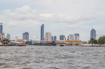 Naklejka premium A Tug boat with a cargo ship on the Chao Phraya River in Bangkok Thailand Southeast Asia