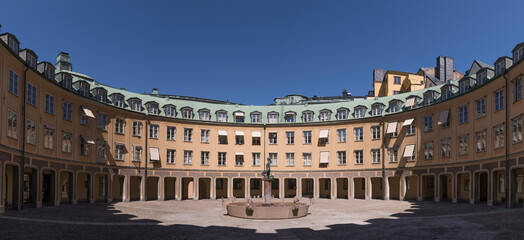 A circular courtyard with statue in the old town Gamla Stan a sunny day in Stockholm