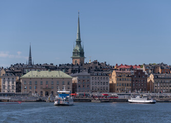 Obraz premium Ferries at a pier in the old town Gamla Stan a sunny day in Stockholm