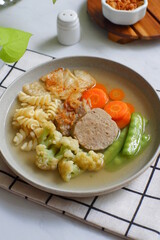 a plate of vegetable soup and meat