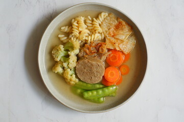 a plate of vegetable soup and meat