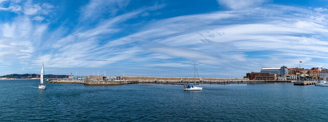Naklejka premium sailboats enter the marina and harbor in the historic old town of Gijon