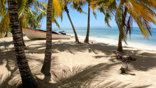 The beach of Mano Juan village, Saona island with old boats, hammocks and an image left in time .4K Video
