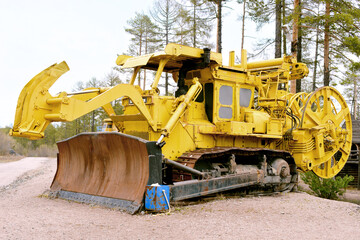 Obraz premium Yellow old mining bulldozer stands rusting in the forest