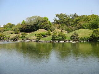 豊富な阿蘇伏流水が湧出して作った池を中心にした桃山式回遊庭園で、築山や浮石、芝生、松などの植木で東海道五十三次の景勝を模したといわれる大名庭園,熊本市にある水前寺成趣園