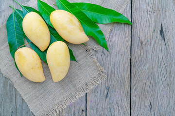 Mango with leaves on wooden table background