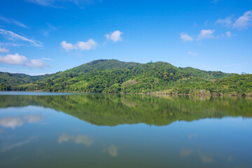 Fototapeta na wymiar Beautiful reflection of clouds in water surface over lake or pond with Mountain tropical forest landscape nature background