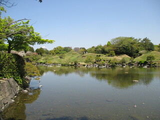 豊富な阿蘇伏流水が湧出して作った池を中心にした桃山式回遊庭園で、築山や浮石、芝生、松などの植木で東海道五十三次の景勝を模したといわれる大名庭園,熊本市にある水前寺成趣園