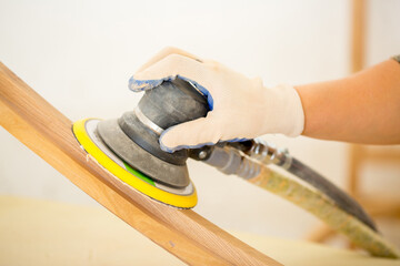 Sanding furniture. Grinding machine close-up in the process. Sanding wooden furniture.