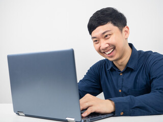 Man sitting and using laptop for working with happy emotion,Male employee working with laptop