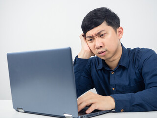 Male employee sitting at office workspace feeling strain looking at laptop