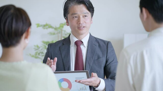 夫婦に営業するビジネスマン
