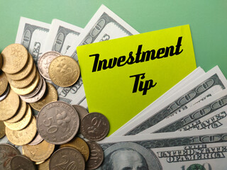 Coins,banknotes and colored note with the word Investment Tip.