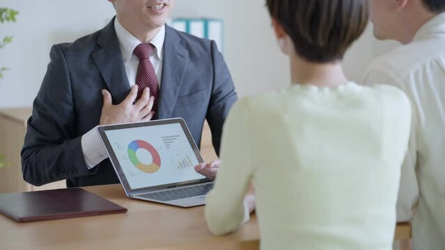 夫婦に営業するビジネスマン