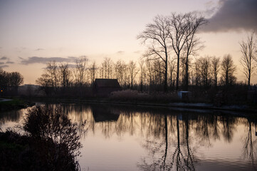 Landscape shot of the Dender river in East Flanders, Belgium, around sunset