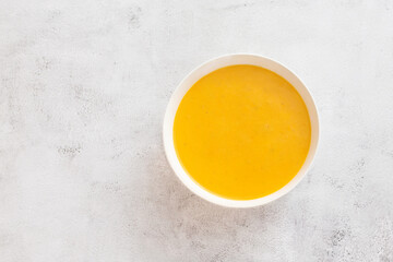 Pumpkin, carrot soup, tadka with parsley on white  background. Top view.