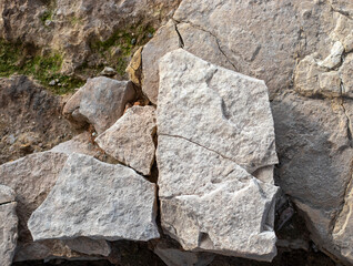 Broken cracked rock wall. Background of stone wall texture. Weathered Stonewall Background from a Castle Wall.