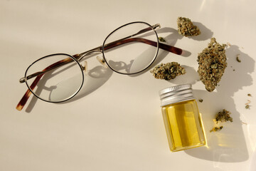 Ophthalmology and cannabis concept. Marijuana buds, ayeglasses and cannabis concentrate oil on...