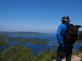 対馬金田城頂上から浅茅湾の島々の絶景を眺める人