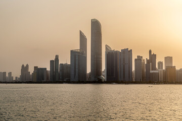 Abu Dhabi skyline at sunrise, view from the seaside. Establishing shot.