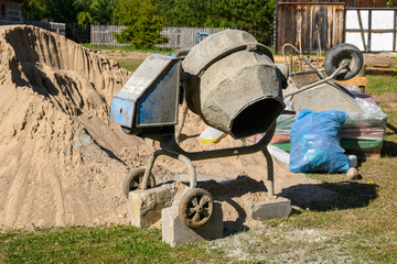 Concrete mixer. Construction site cement mixer machine, tools and sand
