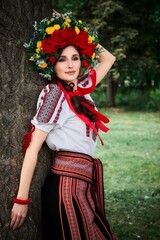 Ukrainian woman in national costume walks in the city park