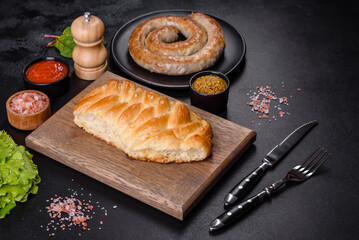 Traditional Ukrainian cabbage pie on a dark concrete background. Baked homemade pie with cabbage