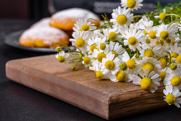 Garden camomile flowers bouquet on a yellow concrete table