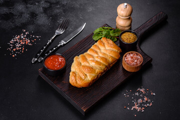 Traditional Ukrainian cabbage pie on a dark concrete background. Baked homemade pie with cabbage