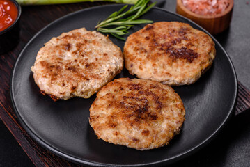 Flat lay composition with grilled meat cutlets for burger on black concrete table