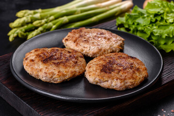 Flat lay composition with grilled meat cutlets for burger on black concrete table