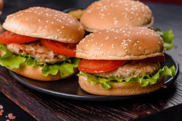 Three hamburger with beef meat burger and fresh vegetables on dark background