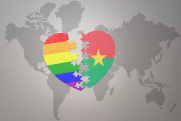 puzzle heart with the rainbow gay flag and burkina faso on a world map background. Concept.