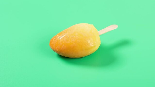 beauty mango shape and mango flavor popsicle melting on green timelapse